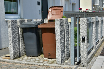 Abfall-Sammelbehälter-Einhausung mit Beton/Steinumfassung vor einer neu gebauten...