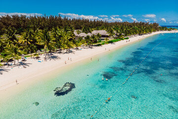 Tropical idyllic beach in Mauritius. Sandy beach with palms and turquoise ocean. Aerial view