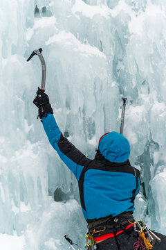 climber climbing a frozen waterfall