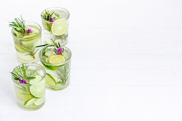 Lemonade with lemon slices and herbs in glasses with lemon reamer - obrazy, fototapety, plakaty