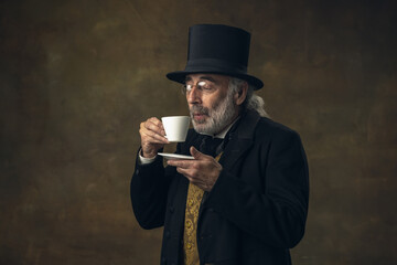 Portrait of elderly gray-haired man, gentleman, aristocrat or actor isolated on dark vintage...