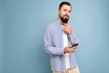 handsome young brunette unshaven man with beard wearing stylish white t-shirt and blue shirt...