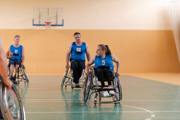 Disabled War veterans mixed race opposing basketball teams in wheelchairs photographed in action while playing an important match in a modern hall. 