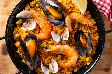 Traditional spanish seafood paella on wooden table	
