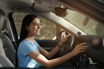 Fototapeta na wymiar Young woman using navigation system while driving car