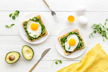 Open sandwich with avocado spinach cream and eggs. Top view