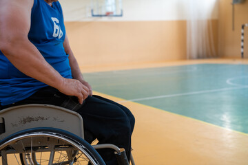 a handicapped basketball player prepares for a match while sitting in a wheelchair.preparations for a professional basketball match. the concept of disability sport