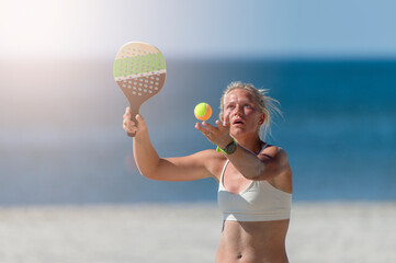 iYoung girl playing beach tennis on sand. Professional sport concept