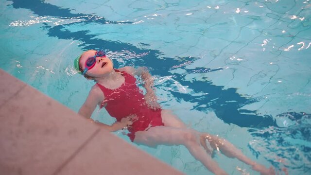 A child learns to swim in the school pool.
