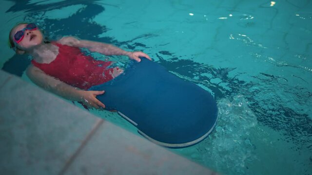 Little girl at the pool learning to swim. - Powered by Adobe