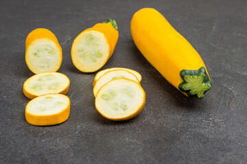 Ripe yellow zucchini, sliced zucchini on Black