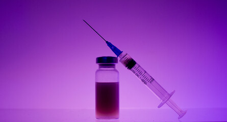 Medicine in a test tube on which lies a syringe. 