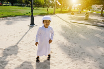 Portrait of Young Arab boy wearing kandoora for kids playing outside during day time. 