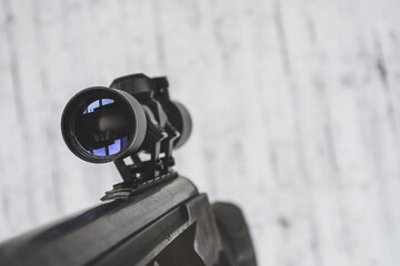 air rifle with an optical sight on a light background