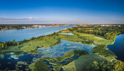 Riga port loading terminal with container ships. Boats and yachts riding on river. Industrial territory meets sustainable environment.
