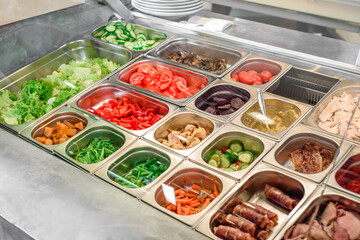 Showcase salad bar with an assortment of ingredients for healthy and dietary food. Salad take away. High quality photo