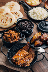 Table served with Venezuelan breakfast, arepas with different types of fillings such as black beans, shredded meat , leg, fried plantain and cheese
