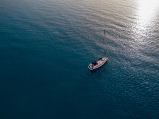 Fototapeta premium Aerial view of a sailboat moored off the coast of Calabria in Tropea. Italy. Tyrrhenian Sea. Coastline and blue sea 