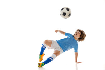 Fototapeta na wymiar Portrait of little male football soccer player, boy training with football ball isolated on white studio background. Concept of sport, game, hobby