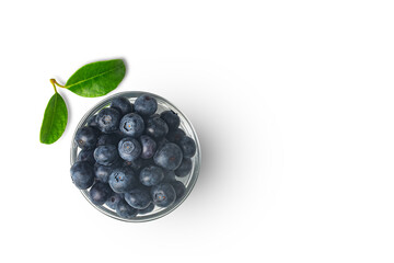 Organic blueberries in transparent bowl isolated on white background with leaf