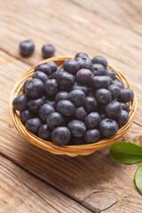 Organic blueberries in a wicker bowl with leaves