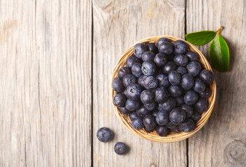 Organic blueberries in a wicker bowl with leaves