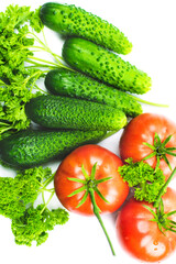 Fresh tomatoes and cucumbers, vegetables and parsley on a white background