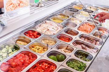 Showcase salad bar with an assortment of ingredients for healthy and dietary food. Salad take away....