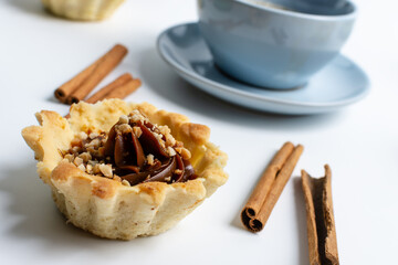cups with coffee and fresh baked goods with nuts, dough on a white background