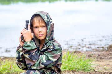 a gun in the hands of a child outdoors