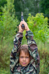 a gun in the hands of a child outdoors