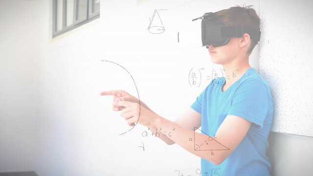 Mathematical equations floating against caucasian boy wearing vr headset at elementary school