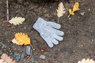 One knitted toddler glove on the Ground in the Soil