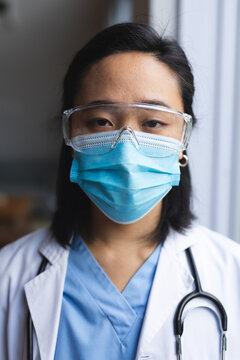 Portrait of asian female doctor wearing face mask at home