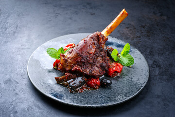 Modern style traditional braised slow cooked lamb shank in red wine sauce with eggplants and...
