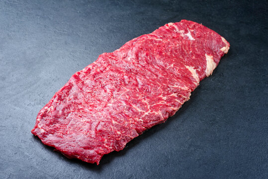 Raw wagyu skirt beef steak offered as close-up on a black board with copy space