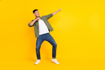 Fototapeta na wymiar Full length body size view of attractive cheerful guy dancing having fun relax isolated over bright yellow color background