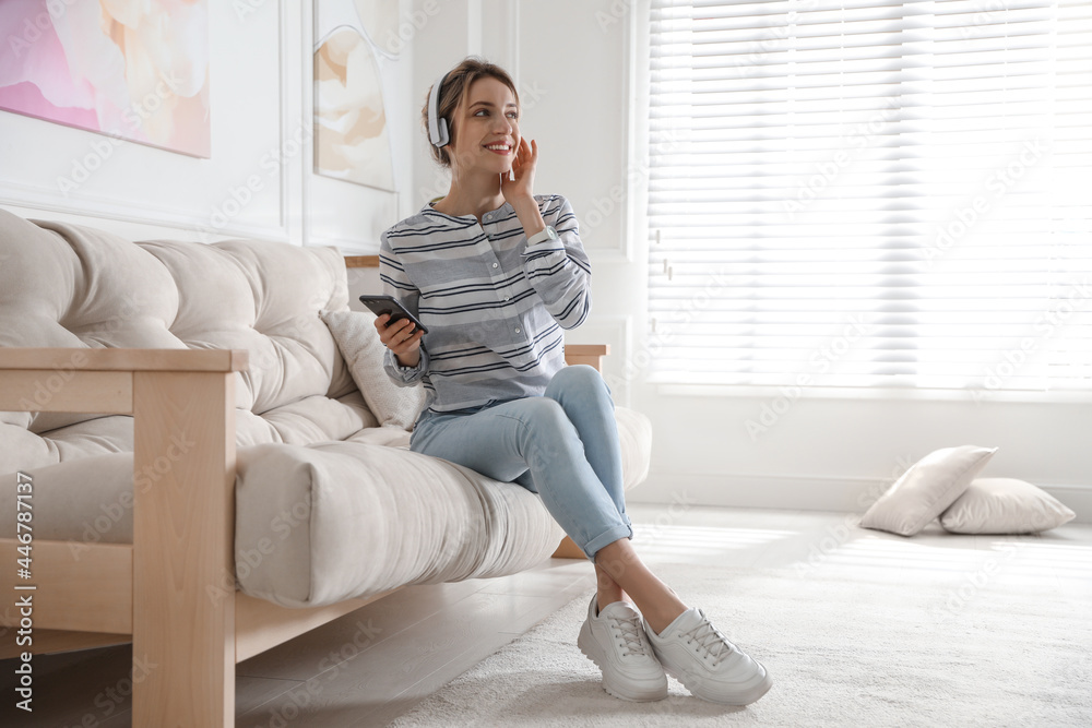 Poster Young woman listening to music at home