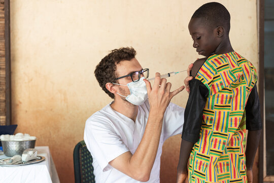 Young white medical volunteer injecting a vaccine during an international campaign