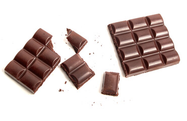 Broken bar of dark aerated chocolate into small pieces on white isolated background.