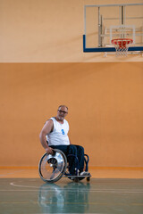 a war invalid in a wheelchair trains with a ball at a basketball club in training with professional...