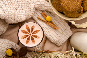 Fototapeta na wymiar Cappuccino coffee with beautiful pattern on foam in white cup against background of burlap decorated with spices. Close up. Space for text. High quality photo