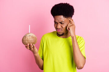 Photo of young african guy unhappy finger touch head dislike coconut cocktail milk isolated over...