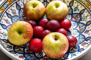 plum, cherry, apple, fruits on color plate