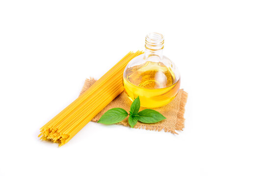 Top view of a bunch of bucatini or perciatelli - pasta, spaghetti with fresh green basil and vegetable oil placed on sackcloth. isolated on a white background