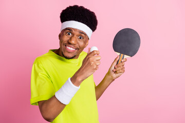 Photo of happy dark skin charming man hold ball ping pong sport smile isolated on pastel pink color...