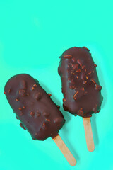 cake - popsicle in Chocolate glaze on a blue background. space for text. Ice cream sweet eskimo with chocolate icing.  Chocolate covered ice cream on stick. Cake sweets