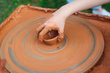 Fototapeta premium Grandmom teaches granddaughter pottery. Clay modeling.