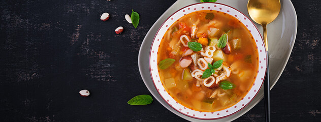Minestrone, italian vegetable soup with pasta on dark table. Top view, flat lay, copy space