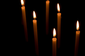 Several candles lit in the dark for religious purposes.